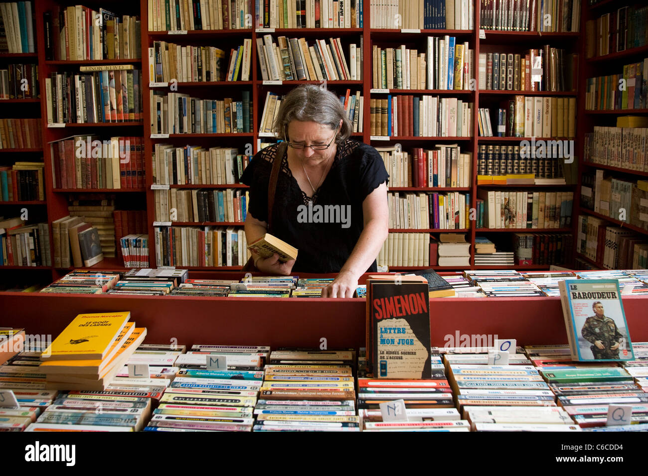 Frau auf der Suche nach Bücher im Buchladen in der Bücherstadt Redu, Ardennen, Luxemburg, Belgien Stockfoto