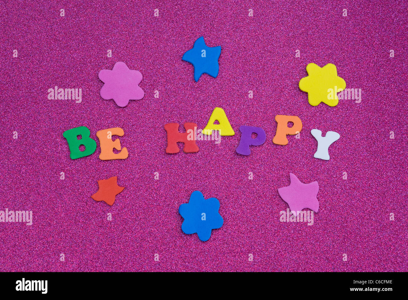 Die Worte "Be Happy" auf einem lila Hintergrund. Stockfoto