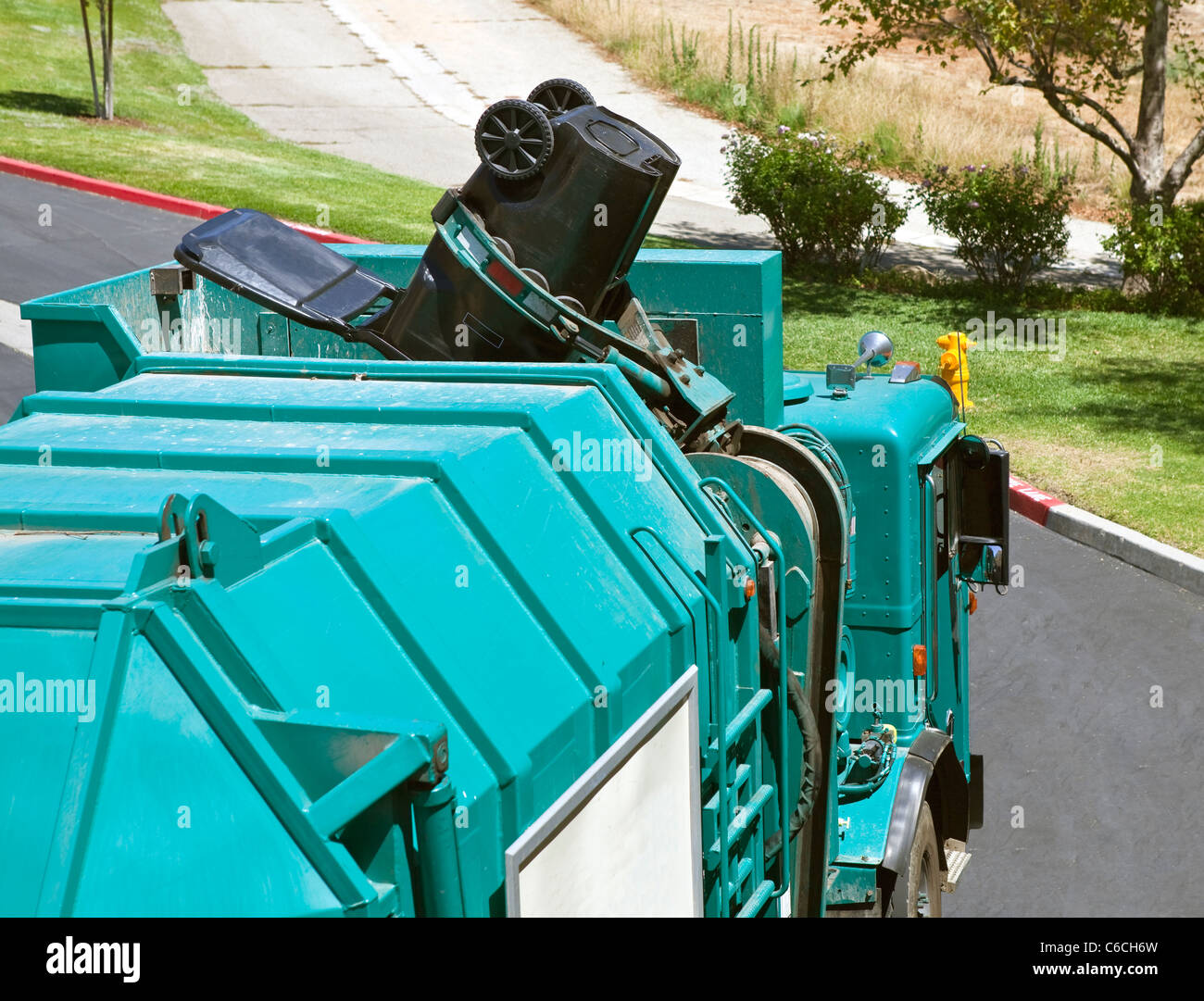 Kommunale Roboterarm Müll LKW sichert eine große schwarze Dose. Stockfoto