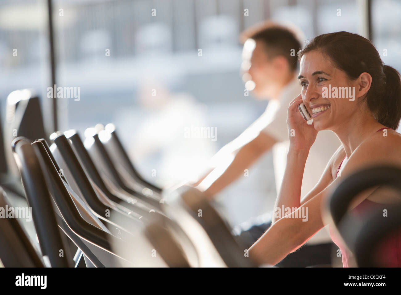 Frau mit Handy auf Laufband Stockfoto