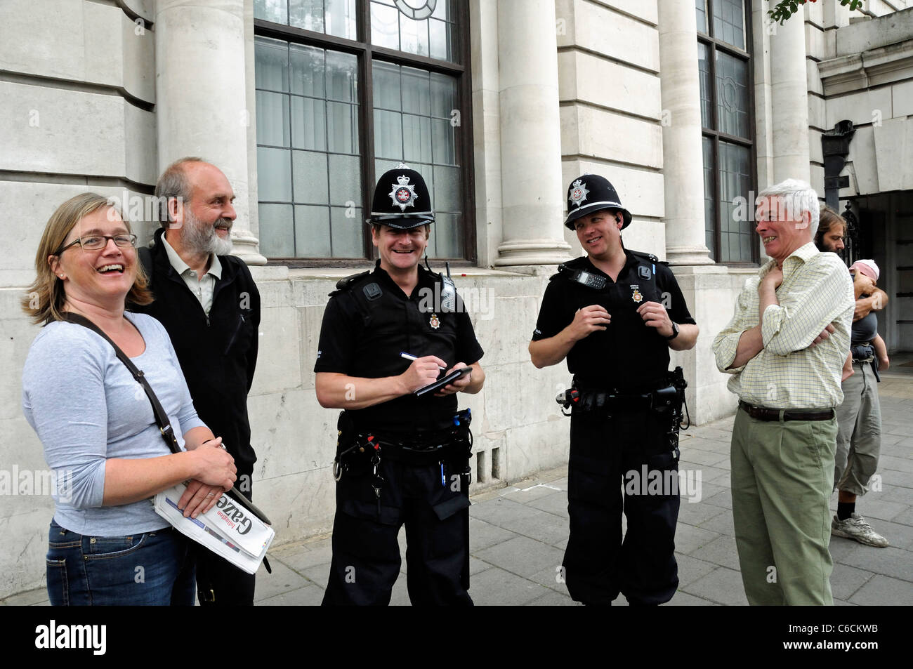 Zwei Welsh Heddlu oder Polizisten, gekleidet in Kampfmontur auf den Straßen von London lachend mit Anwohnern, Holloway Road, Stockfoto