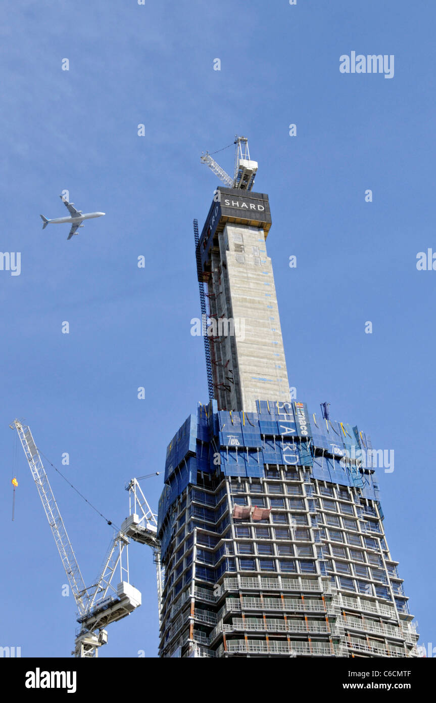 Work in progress auf London Shard Wahrzeichen Wolkenkratzer im Bau befindliches Gebäude mit vier vierstrahligen Jet Airliner fliegen overhead Southwark London Stockfoto