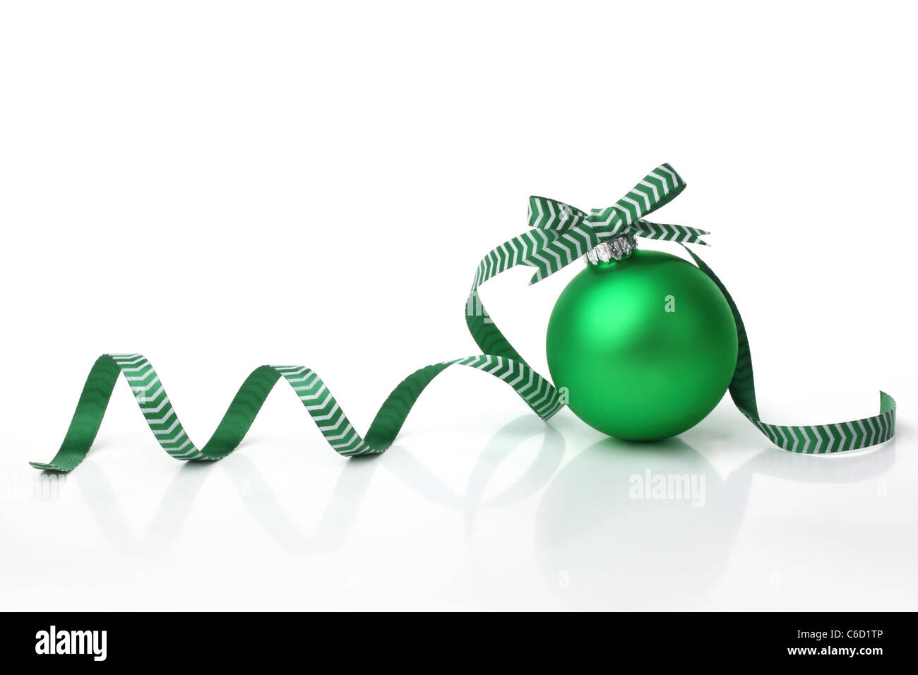 Grüne Weihnachtskugel mit Schleife auf weißem Hintergrund. Stockfoto