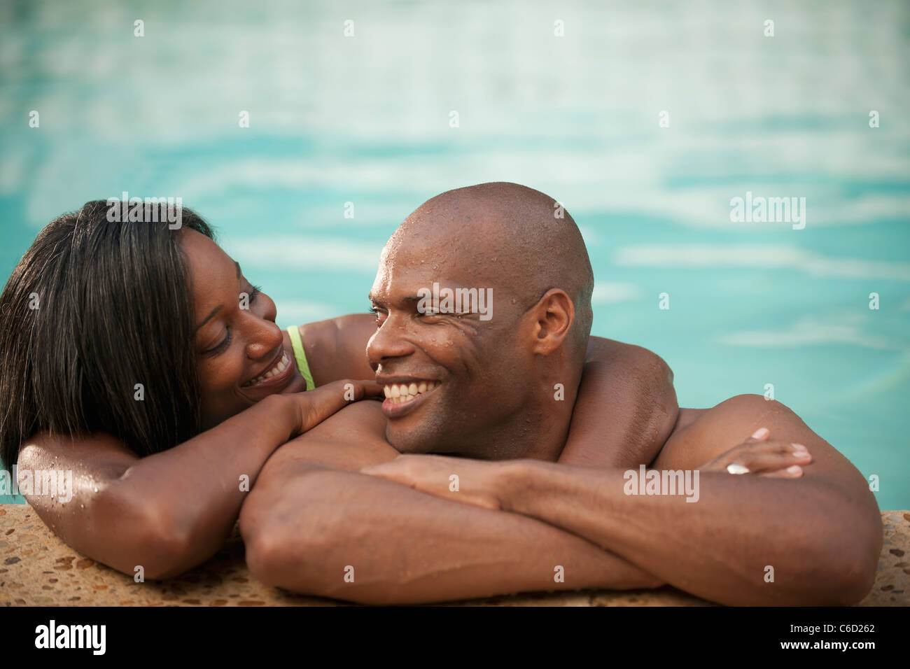 Afrikanische amerikanische paar stützte sich auf den Rand des Schwimmbad Stockfoto
