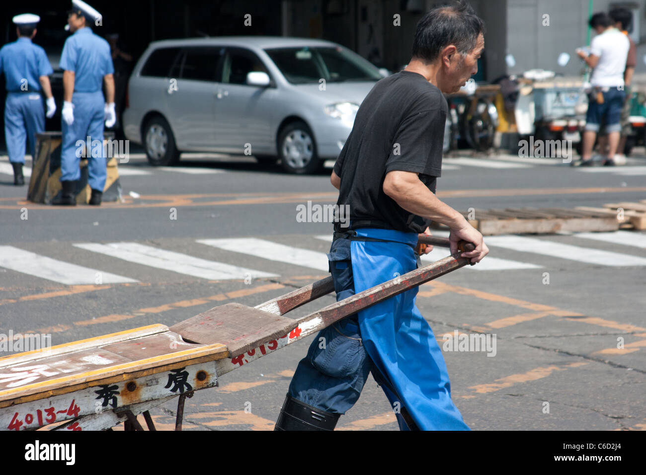 Tsukiji-Marktarbeiter ziehen ein Auto auf dem Parkplatz Stockfoto