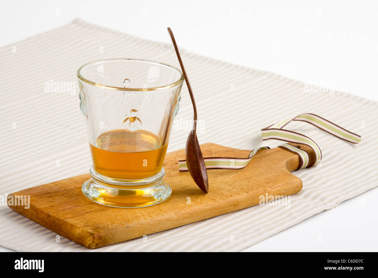 Glas mit Honig und Holzlöffel Stockfoto