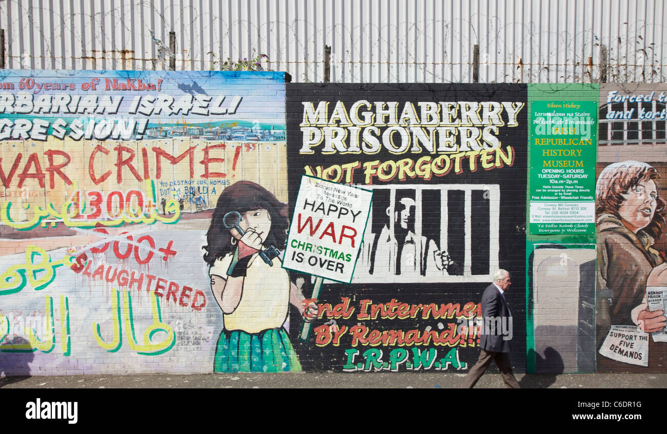 Mann zu Fuß vorbei an politische Plakate auf Falls Road, Belfast, Nordirland Stockfoto