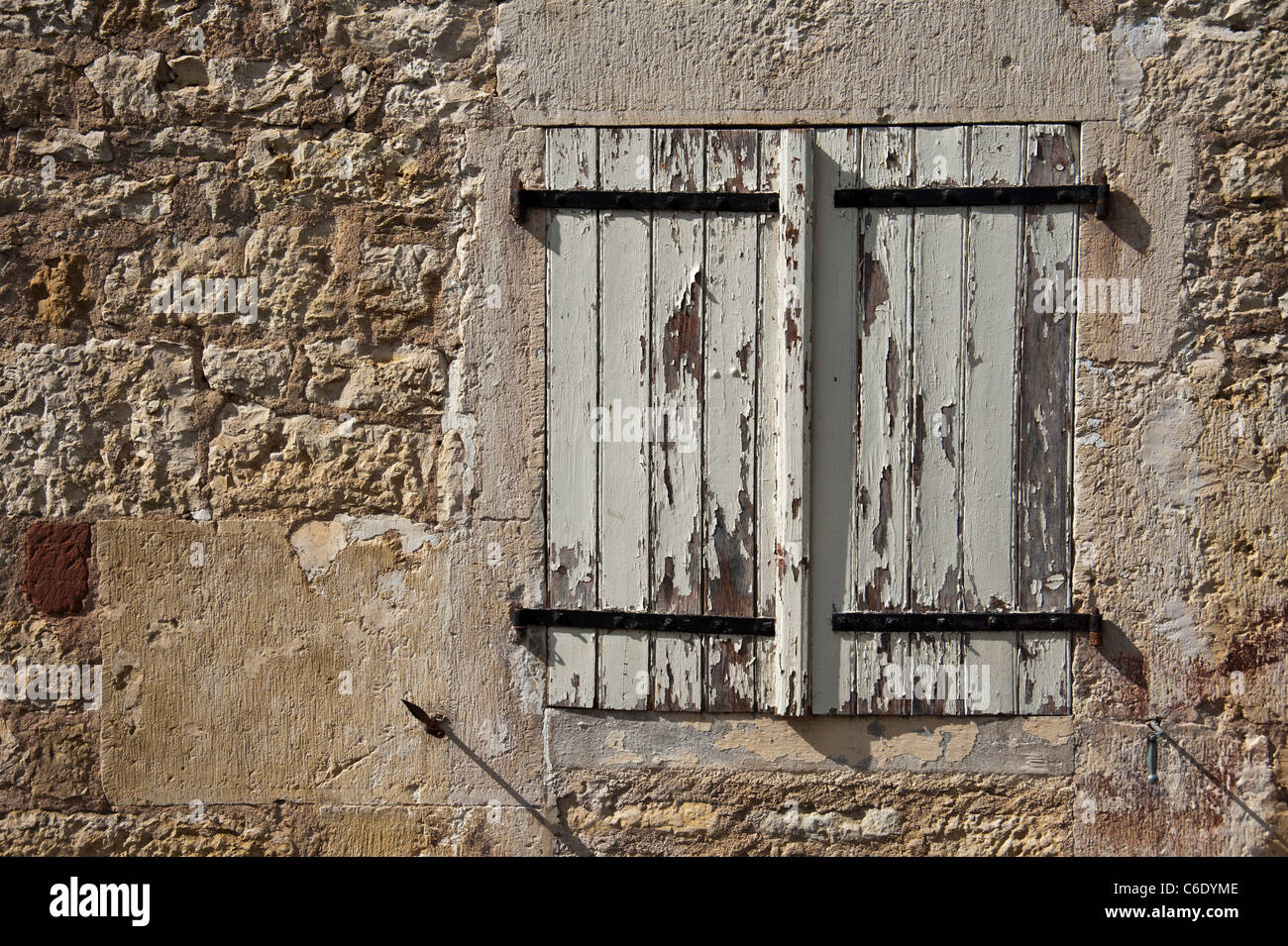 Altes französisches Fenster mit geschlossenen Fensterläden mit abblätternde Farbe Stockfoto