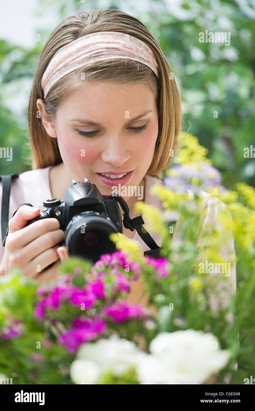 USA, New Jersey, Jersey City, junge Frau fotografieren Blumen Stockfoto