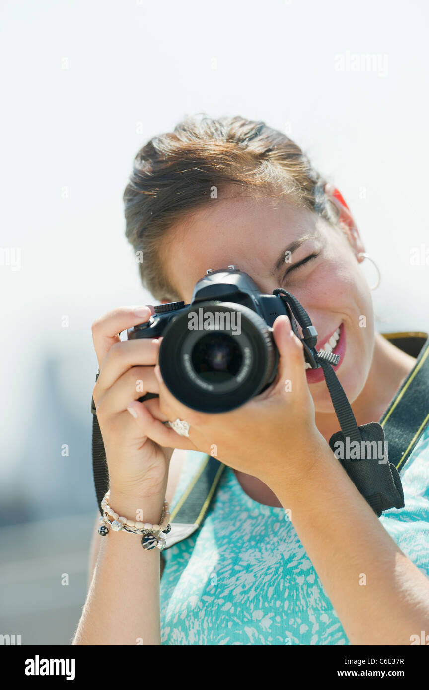 USA, New Jersey, Jersey City, Porträt der jungen Frau, die Aufnahme von Bildern mit Kamera Stockfoto