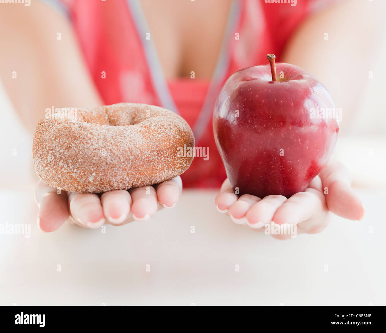 USA, New Jersey, Jersey City, Nahaufnahme von Frauenhand mit Krapfen und Apfel Stockfoto