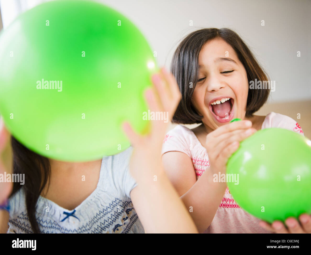 USA, New Jersey, Jersey City, Close Up der beiden Mädchen spielt mit grünen Luftballons Stockfoto