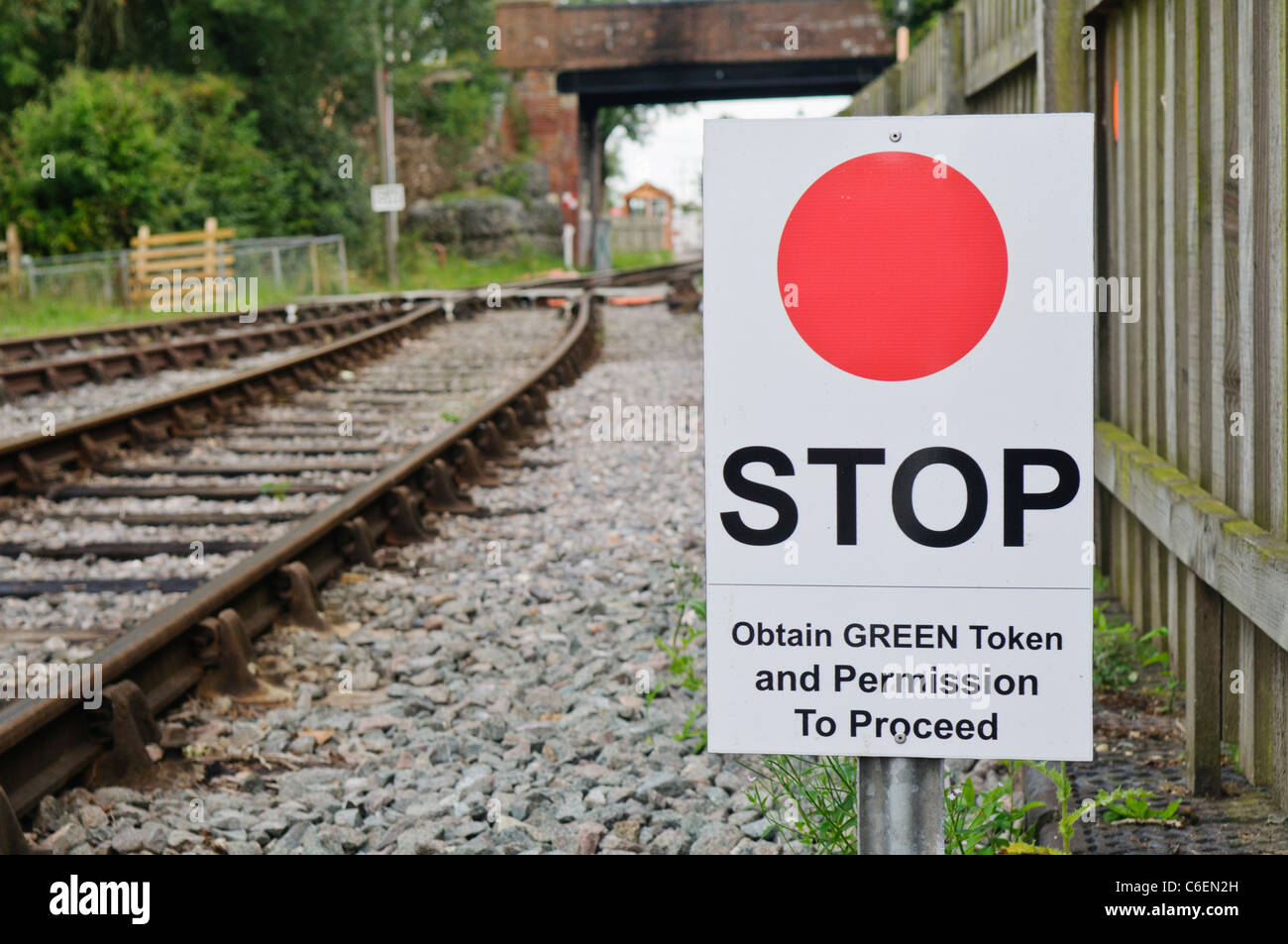 Eisenbahn-Warnschild anweist Lokführer zu stoppen und zu erhalten eine grüne Token und die Erlaubnis, fahren Sie fort. Stockfoto