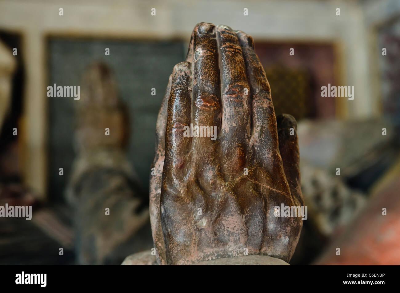 Ineinandergelegten Hände im Gebet auf einem Bildnis auf einem Grab von Sir Edward Baber (1530-1578) in einer englischen Kirche, mit seinem wifes Bildnis im Hintergrund Stockfoto