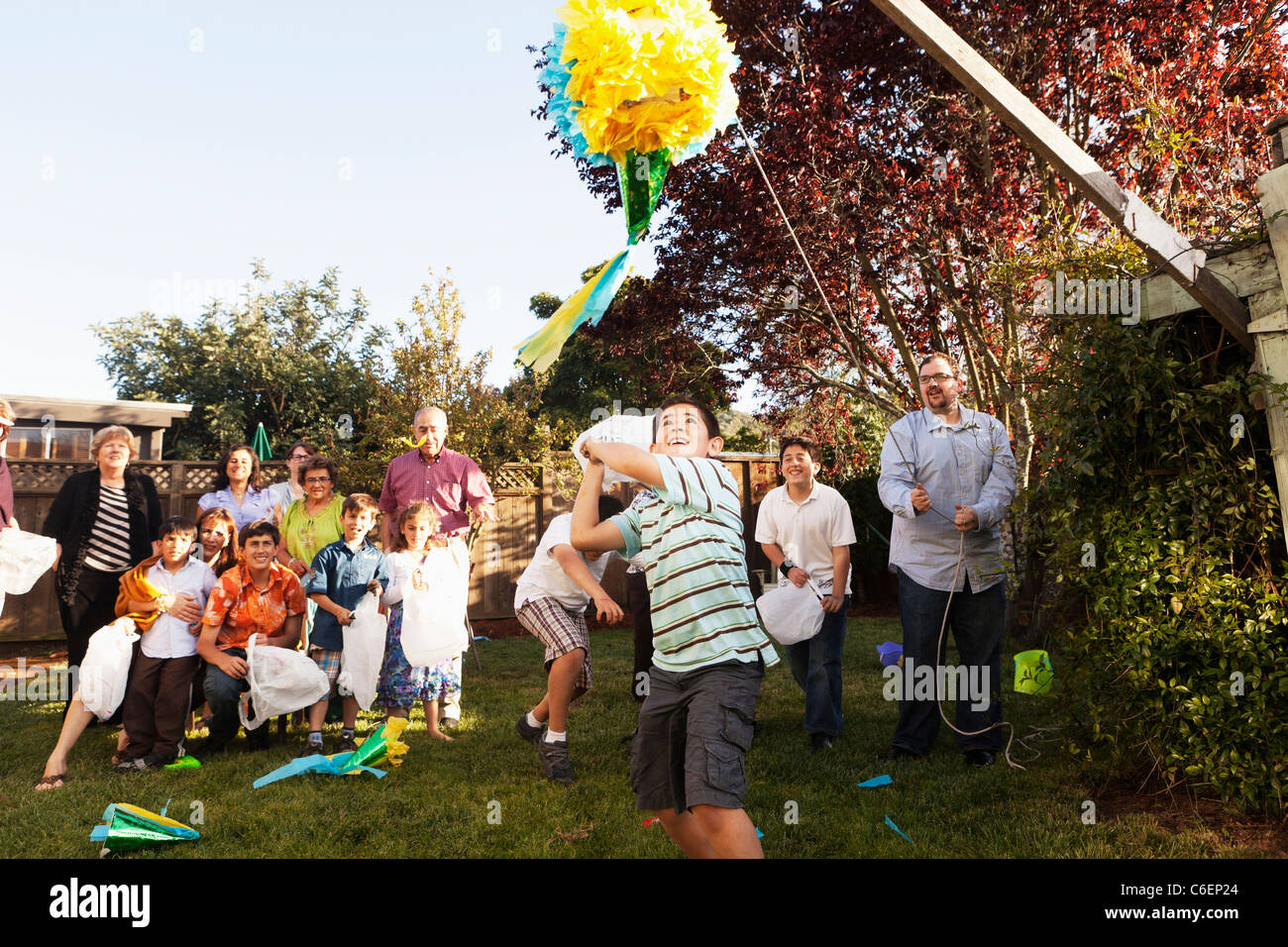 Hispanische Familie brechen Pinata im Hinterhof Stockfoto