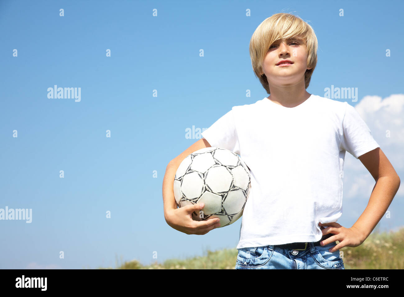 Porträt der niedlichen Teen Boys mit Fußball gegen den blauen Himmel Stockfoto