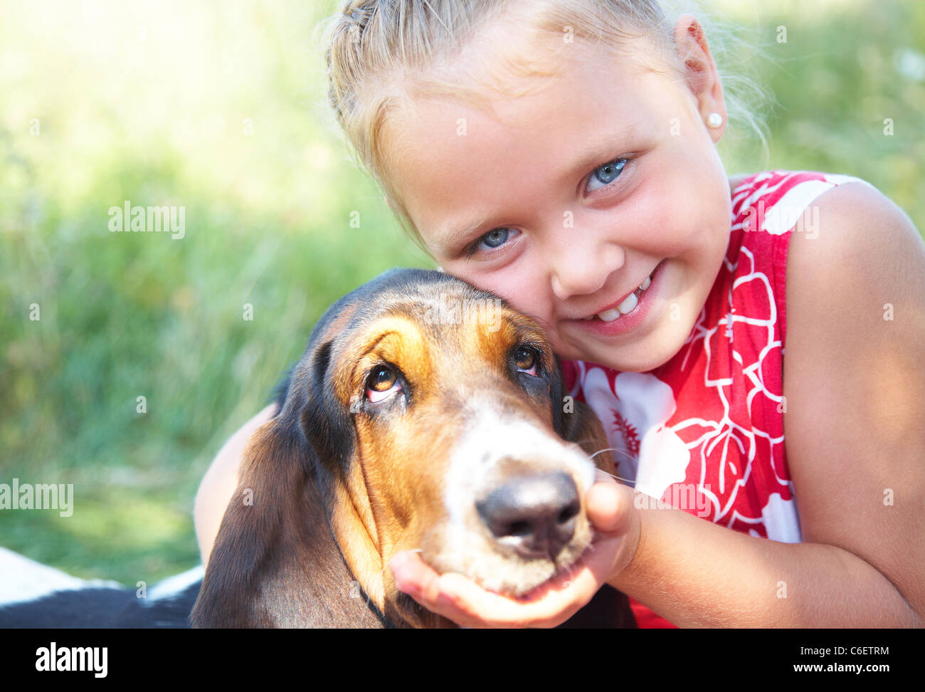 Porträt von niedlichen Mädchen mit Hund auf Sommerwiese Stockfoto