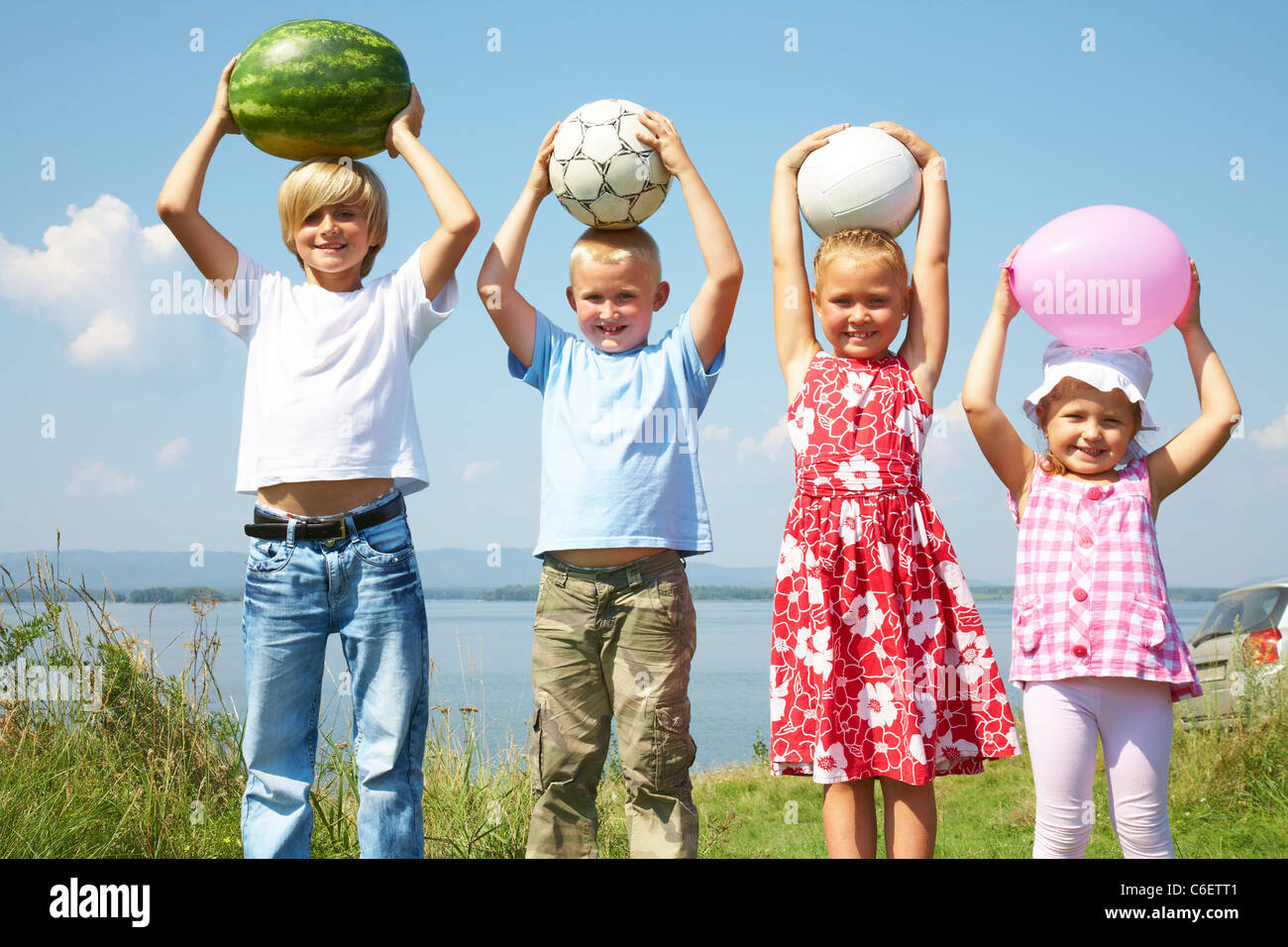 Gruppe von verschiedenen Kindern hält eine Wassermelone, Kugeln und Ballon Stockfoto