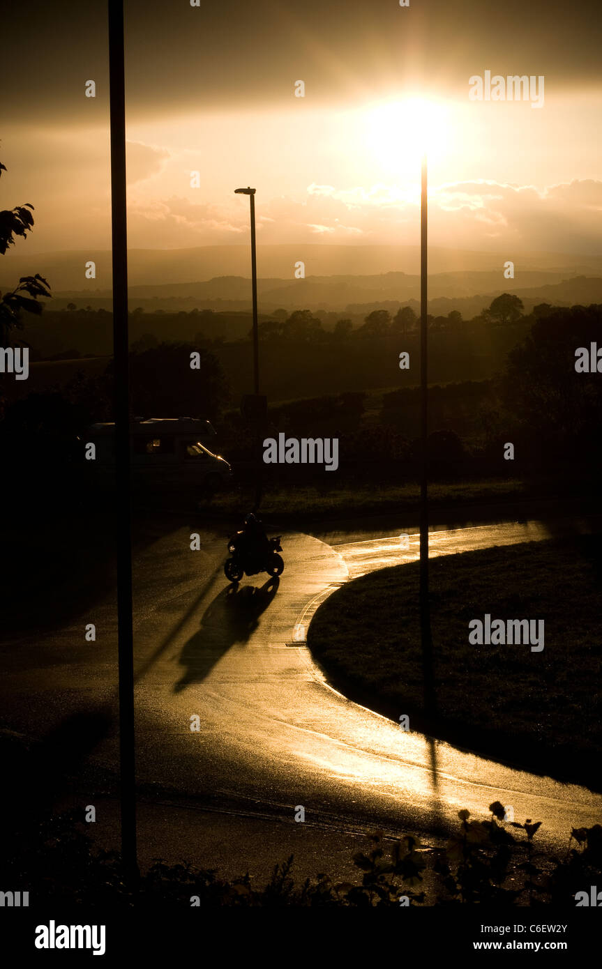 Abstrakte Ansicht der viel befahrenen Straße mit Lampost und Dartmoor. Regen, Reflexion, Straße, Fahrbahn, Stein, Straße, Struktur, Oberfläche, textur Stockfoto