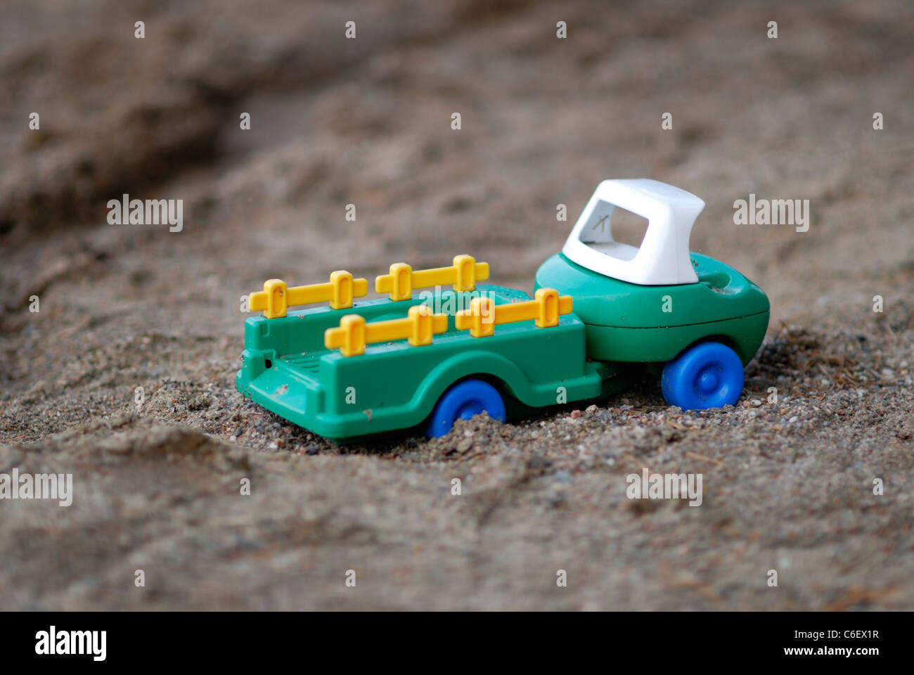 Kunststoff-Spielzeugauto im sand Stockfoto