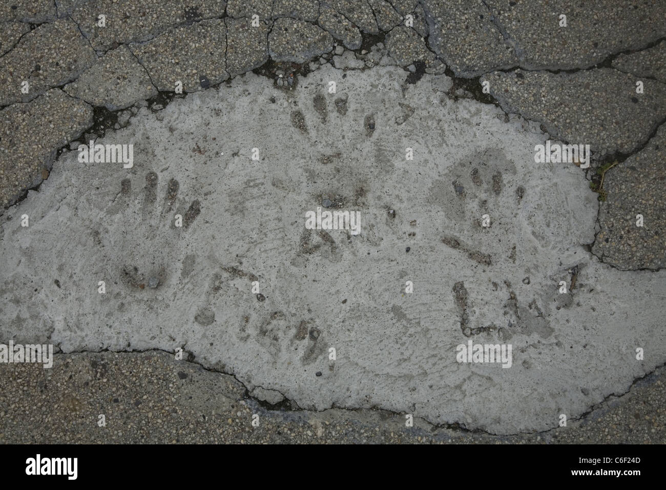 Der Kinder-Hand druckt in Zement auf einen gepatchten Bürgersteig in Brooklyn, New York. Stockfoto