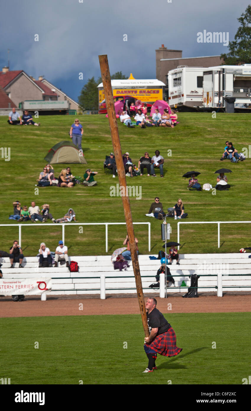 Kilted Konkurrent warf den Baumstamm in den schweren Ereignissen auf der Cowal Highland Gathering 2011 Stockfoto
