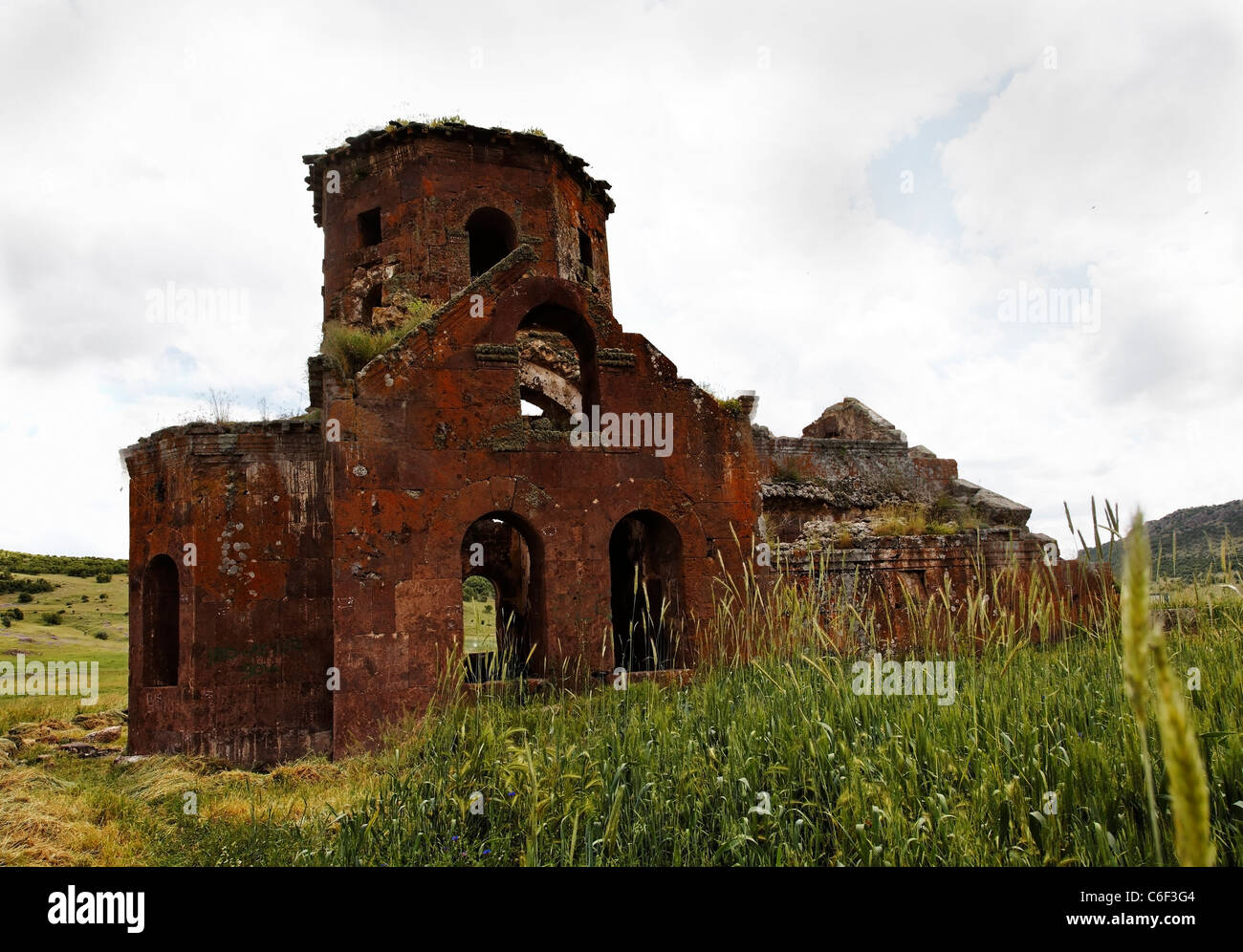 Landschaft Kizil mit sanften Hügeln durch hohe Gräser und weißen Himmel Kilsie, Ruinen Rote Kirche baufällig und verfallene Kirche Stockfoto