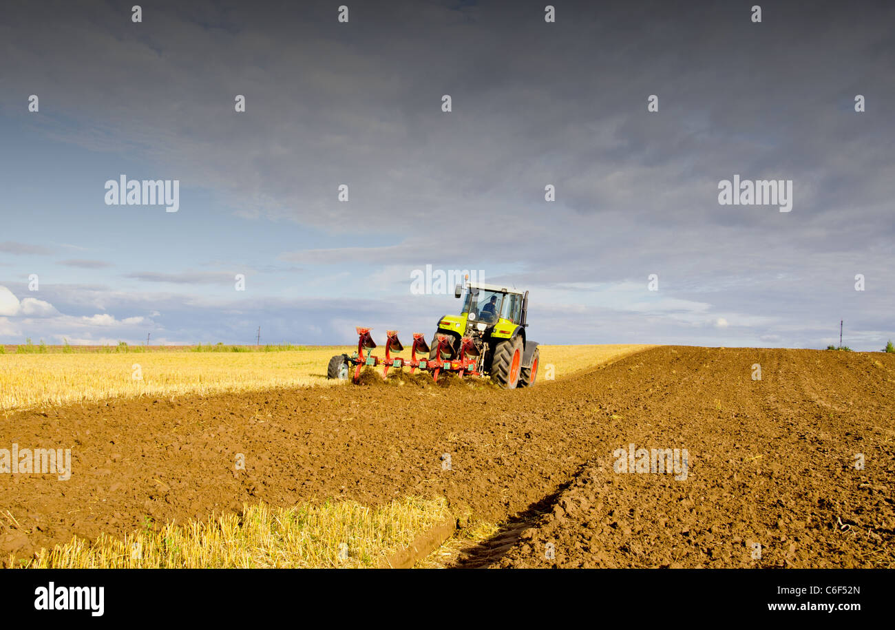 Agrarlandschaft mit Traktor nach der Ernte Stockfoto
