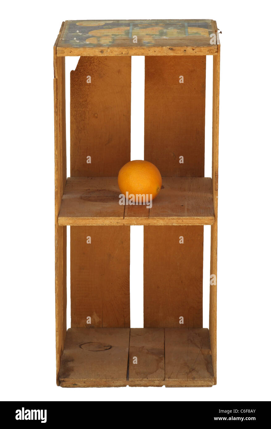 Aufrechte orangefarbene Holzkiste isoliert mit einer Orange auf dem obersten Regal. Die Kiste ist vintage, aber sauber und sieht neu aus. Stockfoto