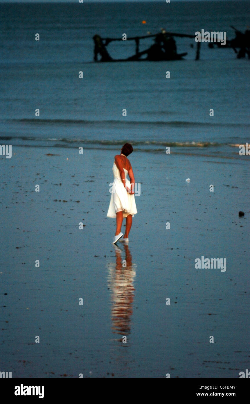Eine einsame Tänzerin-Reflexion beleuchtet den nassen Sand, während sie an der Small Wonder Dance-Produktion Brighton Beach UK 2006 teilnimmt Stockfoto