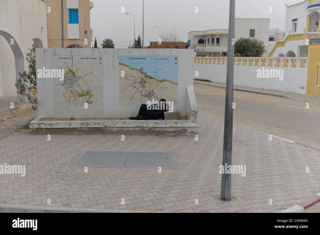 Ein Obdachloser schläft unter einer Karte der Insel Djerba. Tunesien. Nordafrika Stockfoto