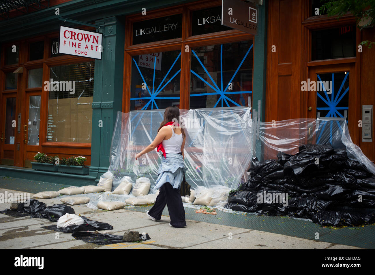 Eine Frau geht durch den Sand eingesackt Galerie im Stadtteil Soho in New York nach Hurrikan Irene geht Stockfoto