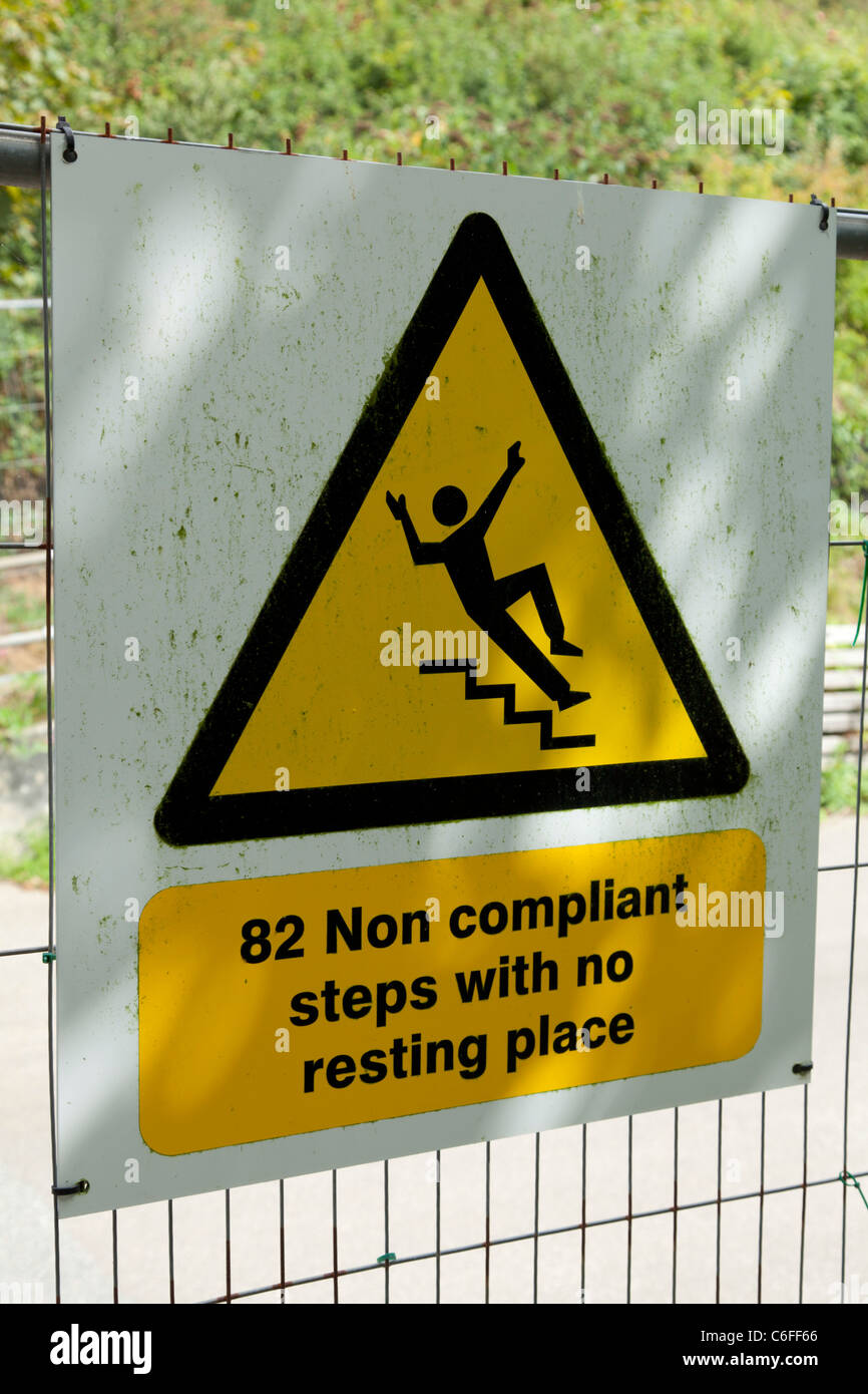 Schritte, die Warnung beachten orangefarbenes Dreieck auf einem Draht Zaun 82 nicht konforme Schritte mit keine Ruhe Platz Baustelle Stockfoto