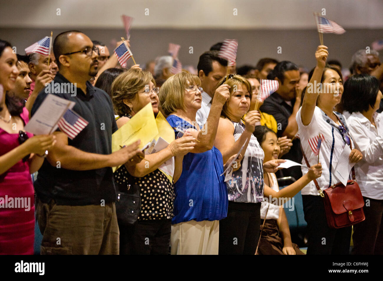 Immigranten von vielen Altersgruppen und Nationalitäten jubeln und winken US-Flaggen nach der Eidesleistung der Vereinigte Staaten Staatsbürgerschaft. Stockfoto