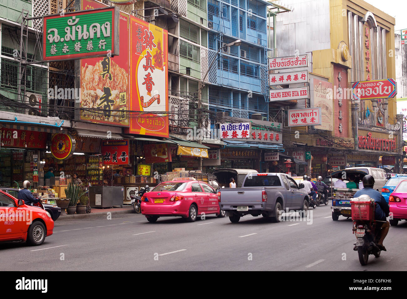 Belebte Straße mit bunten Taxis und viele Zeichen in Chinatown im Stadtteil Samphanthawong von Bangkok Stockfoto