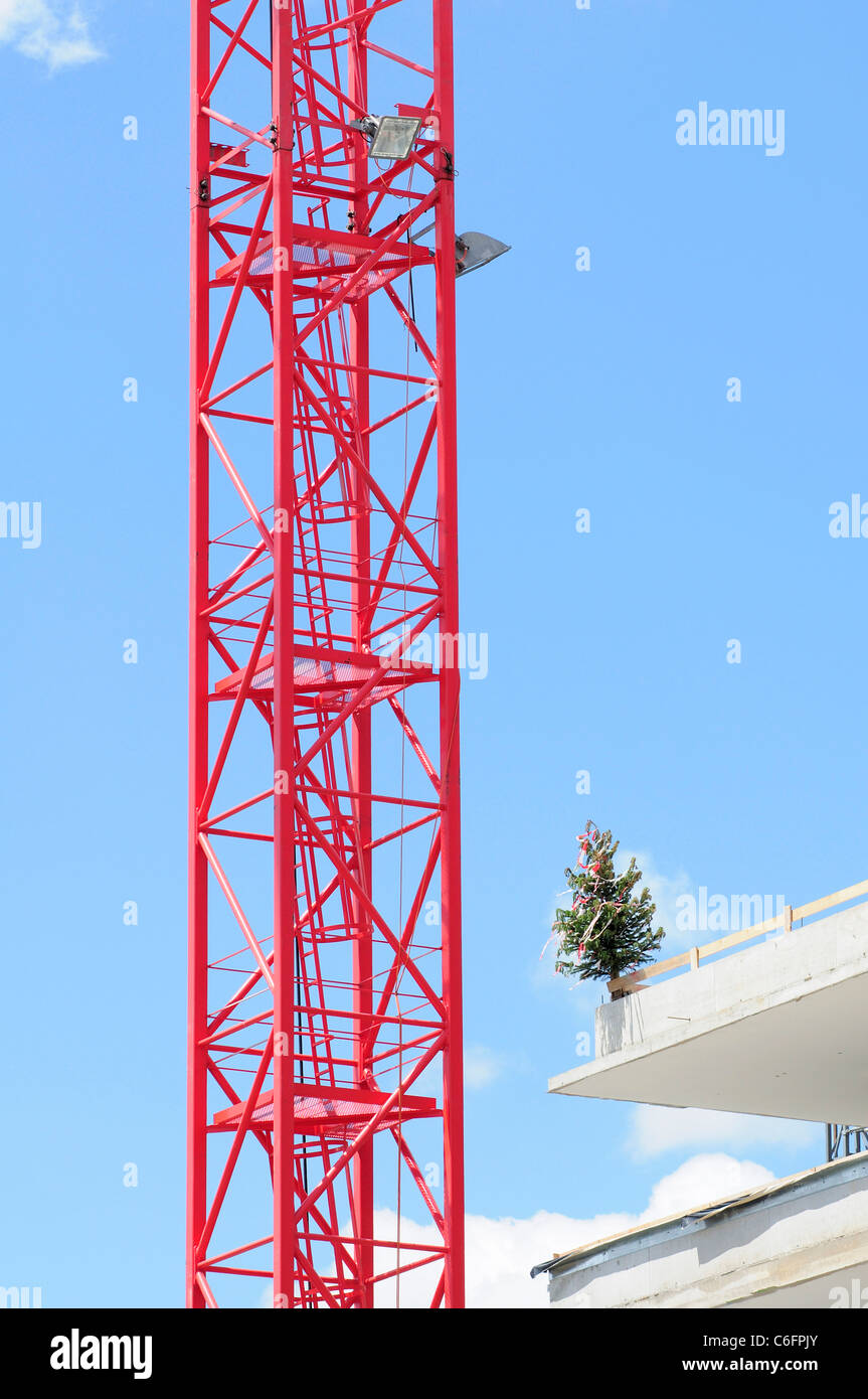 Rote Kran mit Richtfest Baum auf einer Baustelle Stockfoto