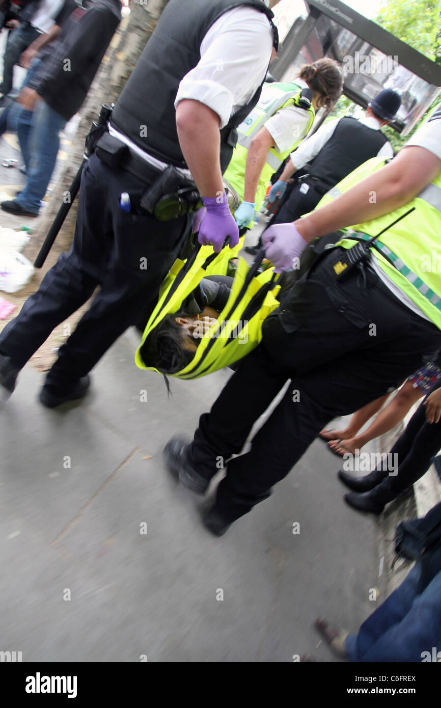Polizei tragen Mann erstochen in Notting Hill Carnival, London, UK. Stockfoto