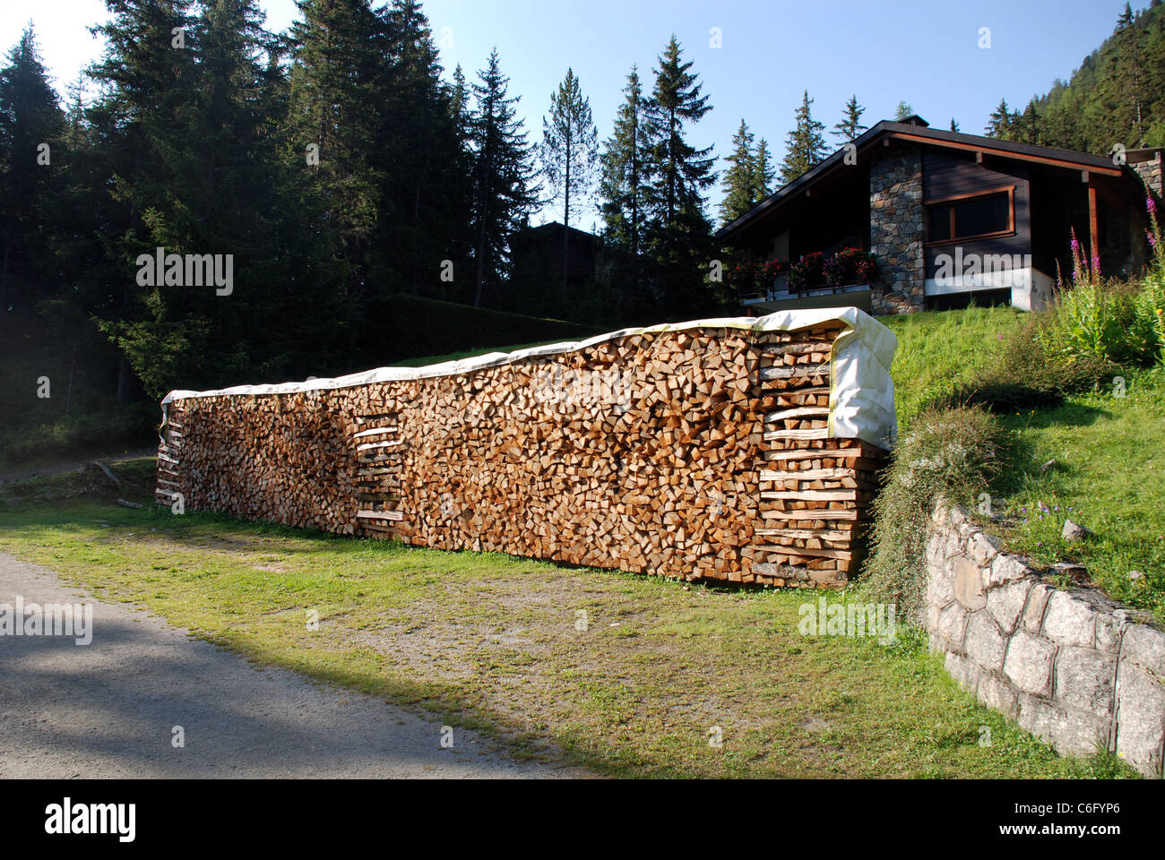 nachhaltigen erneuerbaren Heizung in Form von einem großen Holzstapel vor  einem Haus in einem Tal in der Schweiz Stockfotografie - Alamy