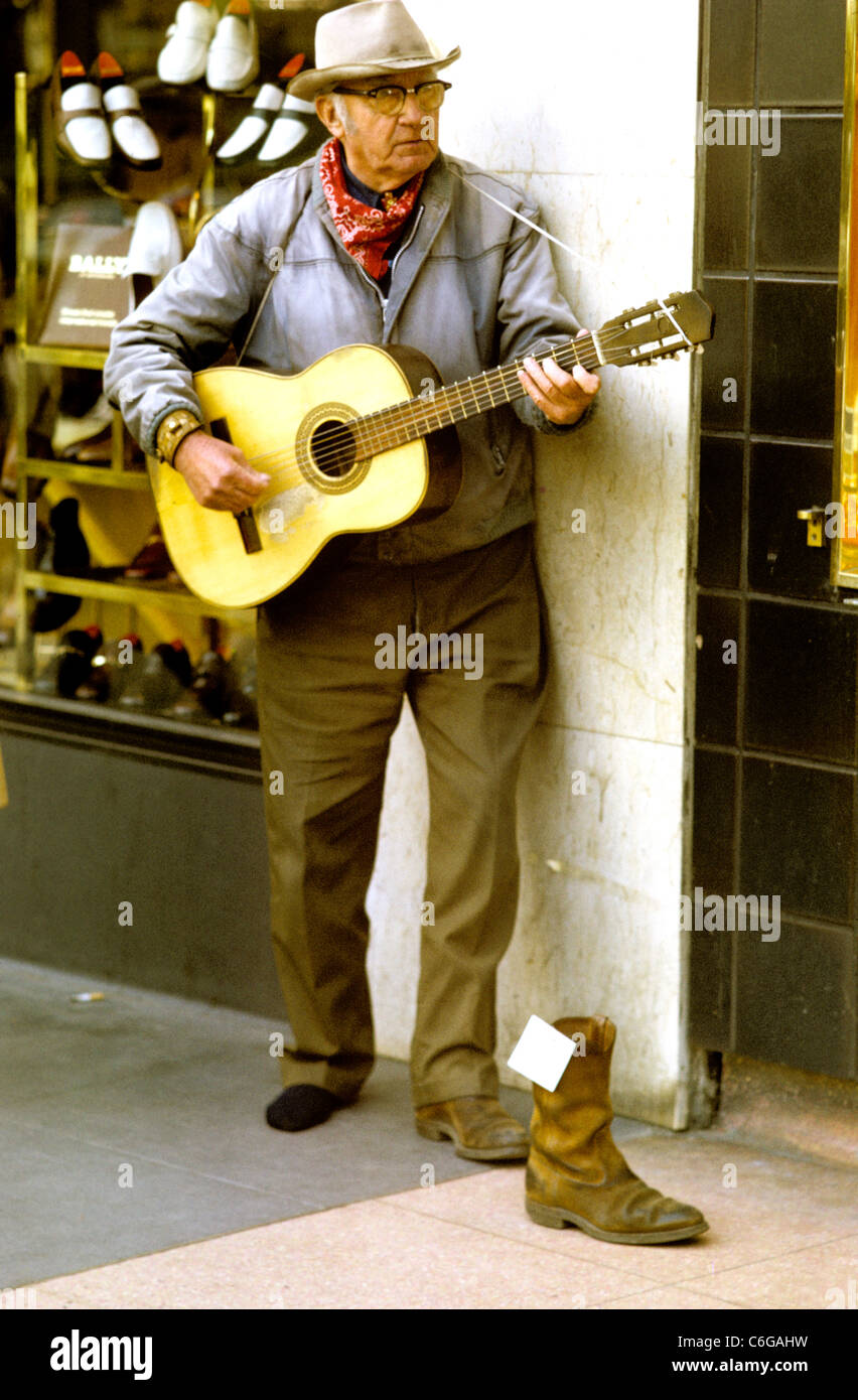 Alter Mann mit Cowboyhut und Stiefel, Gitarre zu spielen und bitten um  Spenden in seine Cowboystiefel platziert werden Stockfotografie - Alamy