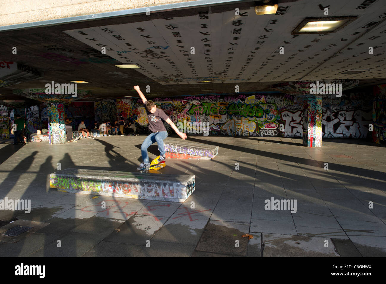 Ein einsamer Mann Skateboarder üben am Südufer, London, erschossen bei niedriger Geschwindigkeit um Bewegung erfassen verwischen. Stockfoto