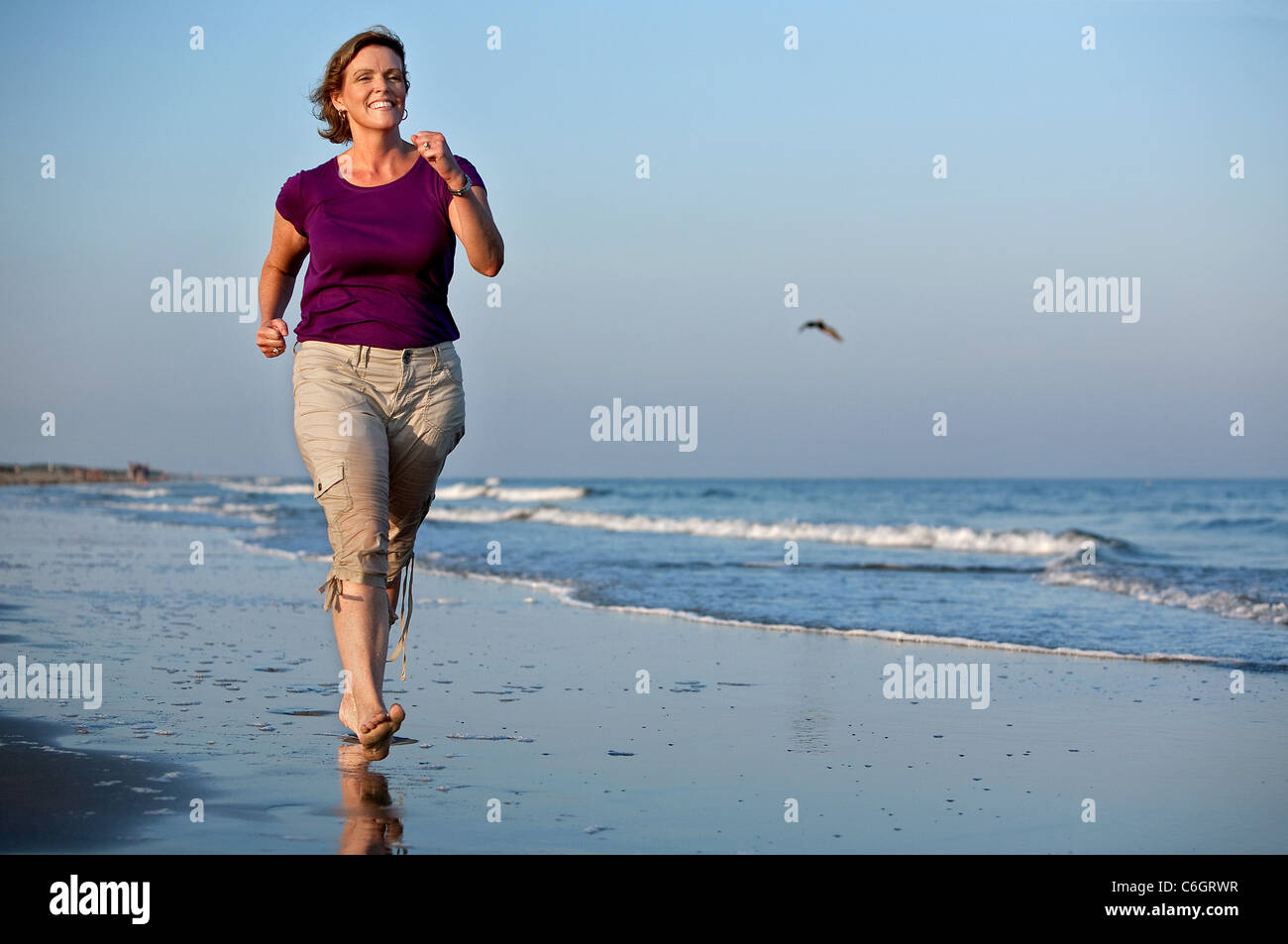 Eine Frau erzählt einen Spaziergang am Strand auf Sullivans Island, South Carolina. Stockfoto