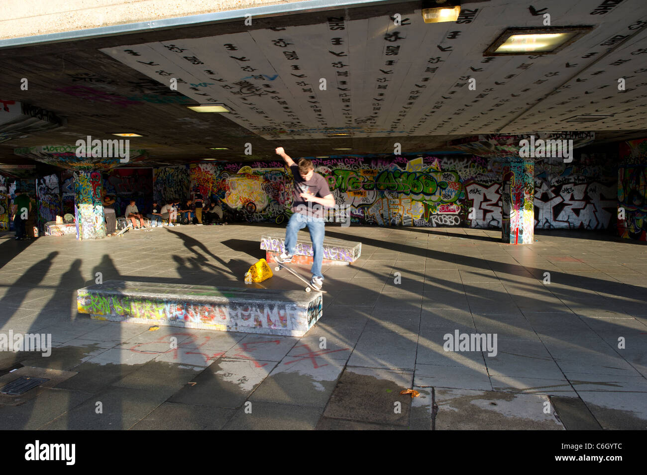 Ein einsamer Mann Skateboarder üben am Südufer, London, erschossen bei niedriger Geschwindigkeit um Bewegung erfassen verwischen. Stockfoto