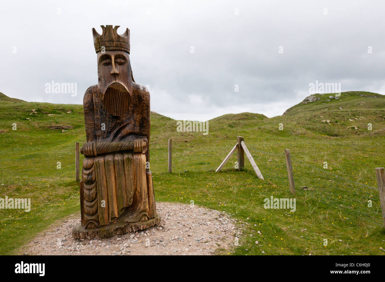 Geschnitzte hölzerne Darstellung eines Königs von Lewis-Schachspiel in der Nähe der Dünen, wo es gefunden wurde, Traigh Uige auf den Hebriden. Stockfoto