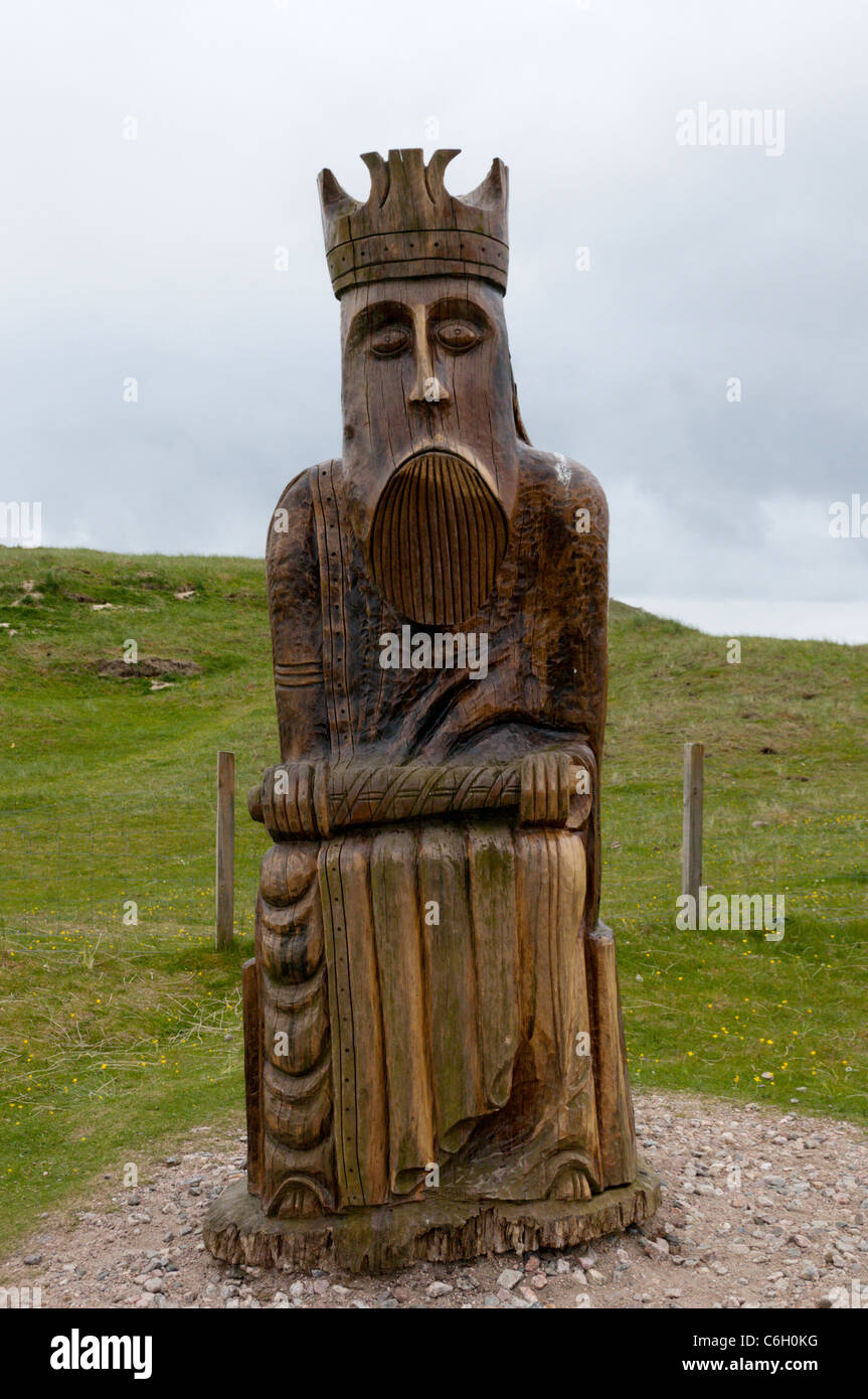 Geschnitzte hölzerne Darstellung eines Königs von Lewis-Schachspiel in der Nähe der Dünen, wo es gefunden wurde, Traigh Uige auf den Hebriden. Stockfoto