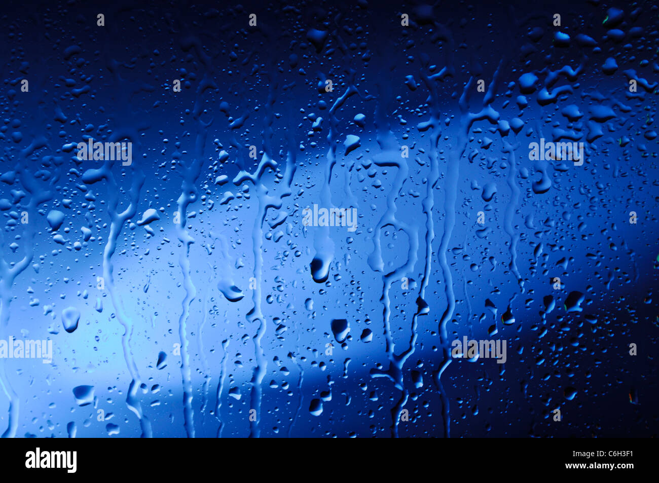 Blaues Glas mit Wassertropfen abstrakte künstlerische Hintergrundtextur nass Stockfoto