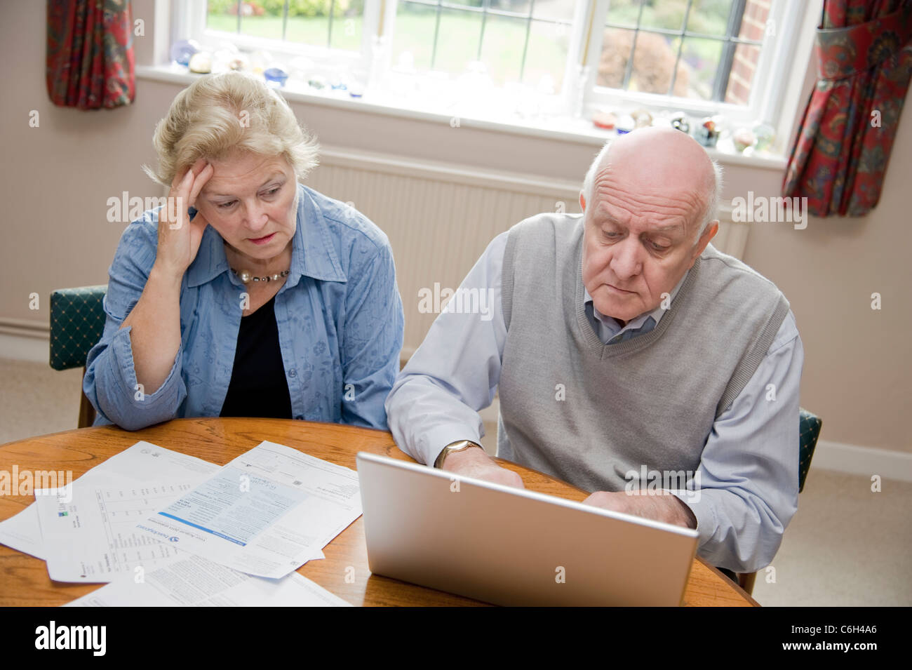 Älteres Paar mit einem Laptop-Computer, sich Gedanken über ihre Rechnungen und Schulden online Stockfoto