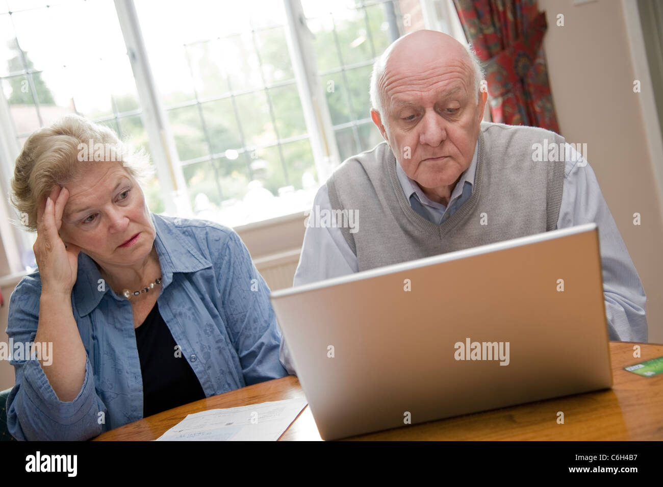 Älteres Paar mit einem Laptop-Computer, sich Gedanken über ihre Rechnungen und Schulden Stockfoto