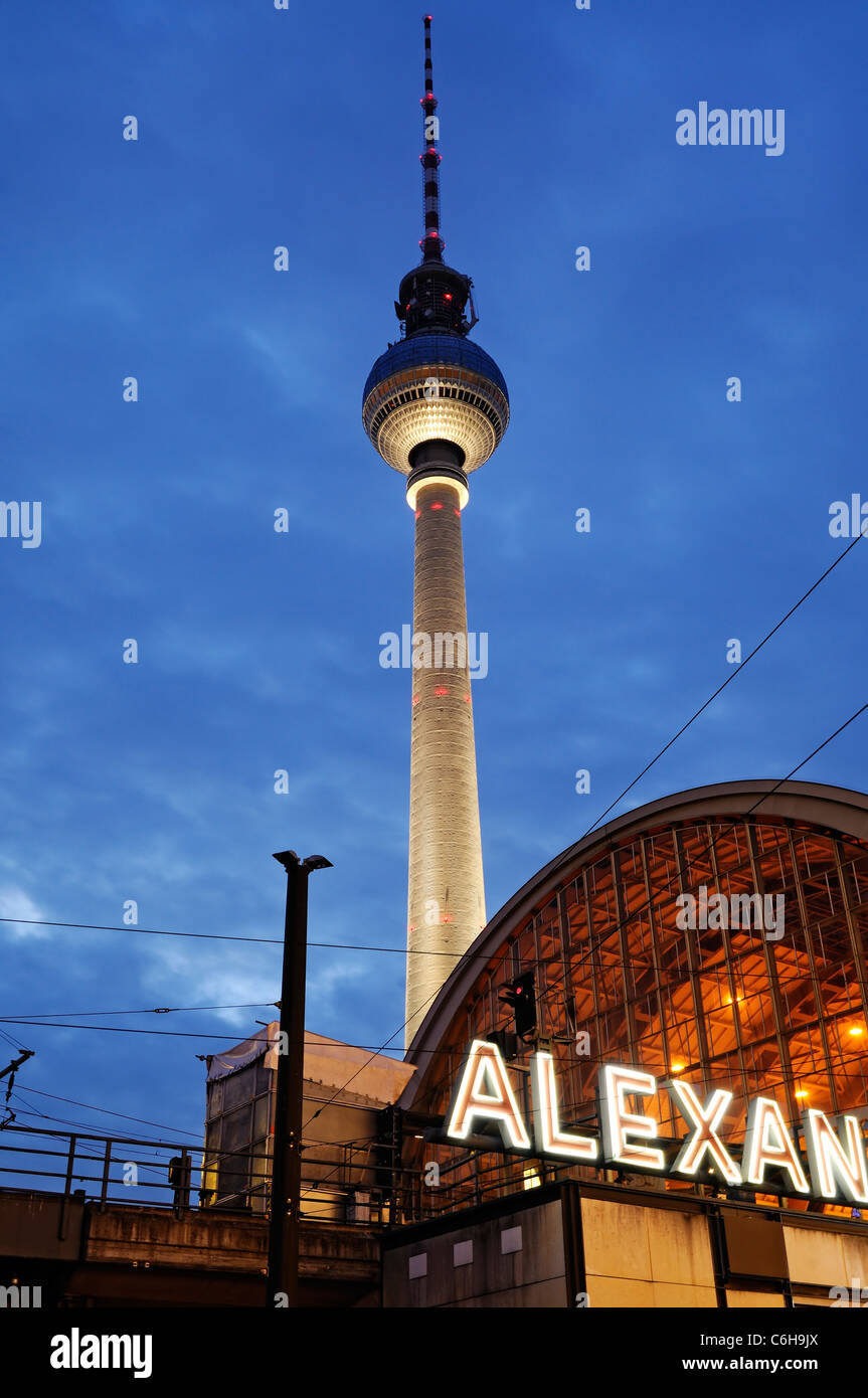 Nachtaufnahme vom Bahnhof Berlin Alexanderplatz mit dem berühmten Fernsehturm im Hintergrund. Stockfoto