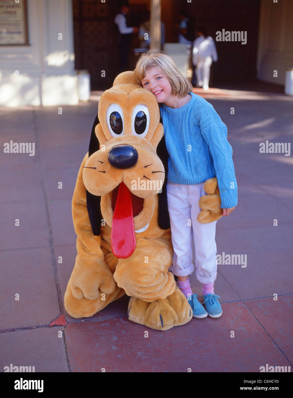 Junges Mädchen mit Pluto-Charakter, Fantasyland, Disneyland, Anaheim, Kalifornien, Vereinigte Staaten von Amerika Stockfoto