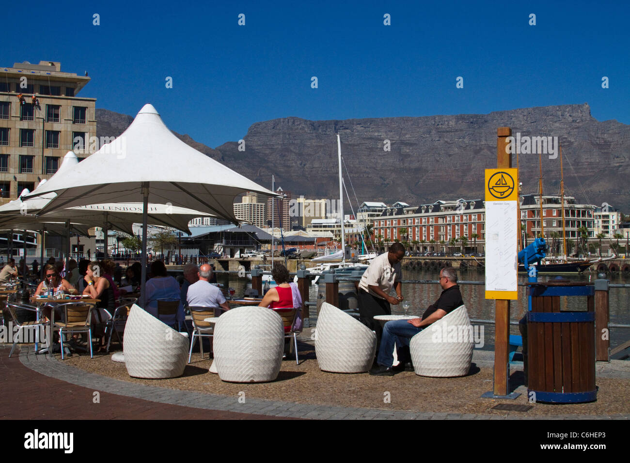 Touristen in ein Café im Freien in der V & A Waterfront angesehen vor dem Hintergrund der Tafelberg Stockfoto